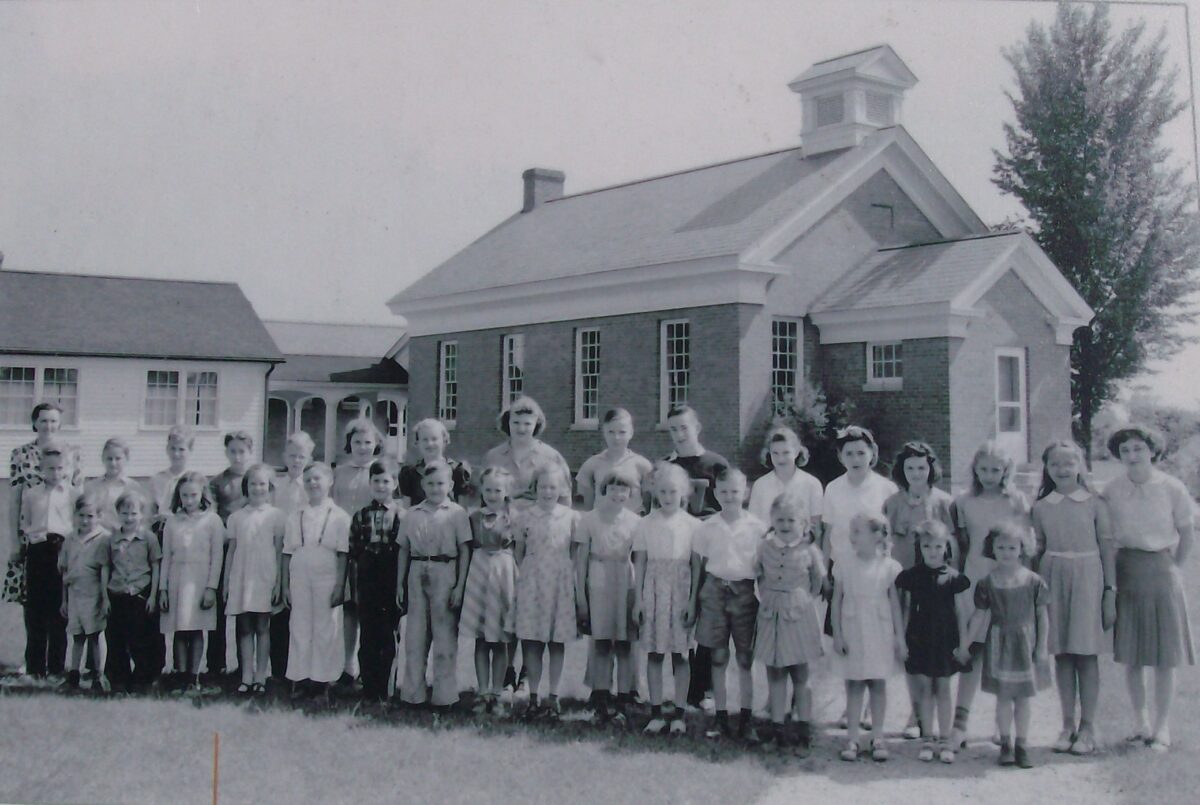 Black and white photos of children and teachers standing in front of school